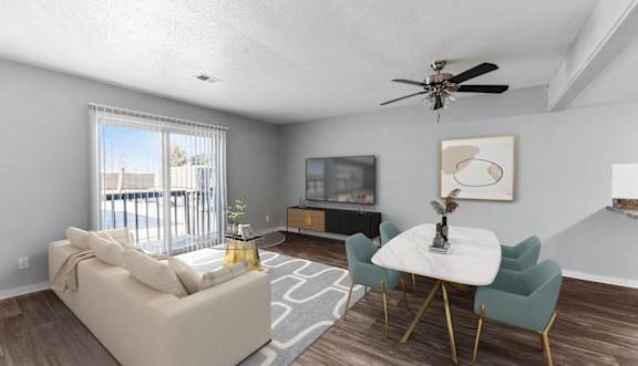 A living room with a white couch, a white coffee table, and a ceiling fan.