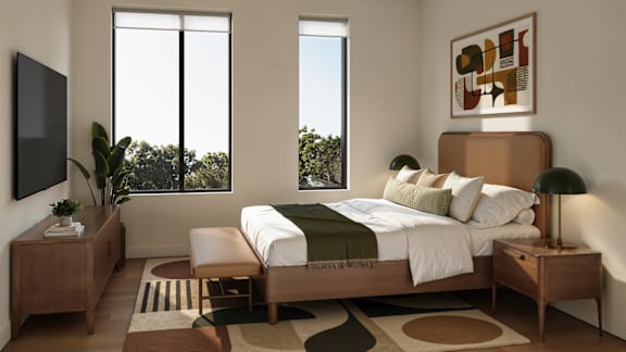 A bedroom with a large bed and a flat screen TV mounted on the wall.