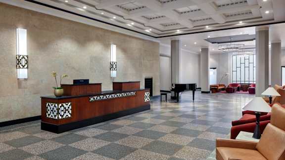 A reception area with a checkered floor and a brown sofa.
