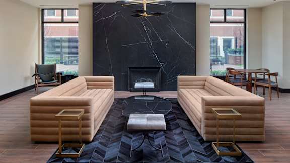 A living room with a fireplace and a black marble mantle.