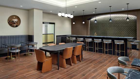 A modern dining room with a dark wood table and chairs.
