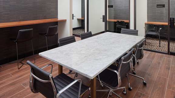 A conference room with a long table and chairs.