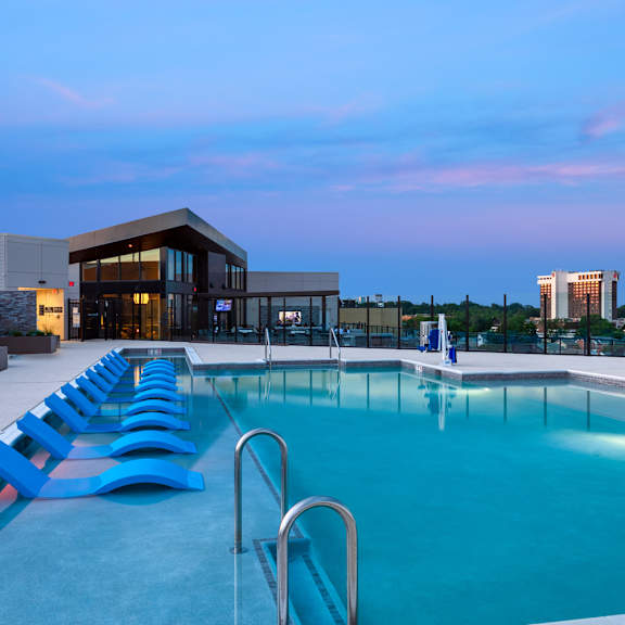 A swimming pool with a slide and lounge chairs.