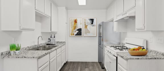 a white kitchen with marble counter tops and stainless steel appliances
