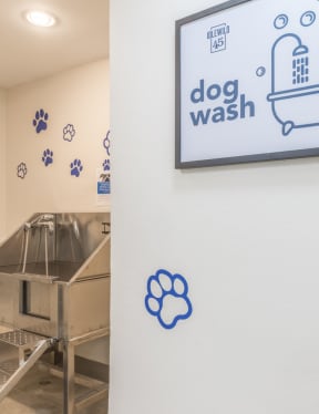 a dog wash room with a sign that says dog wash and a dog in a bathtub