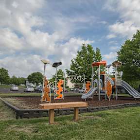 A playground with a slide, swings, and a climbing structure. at Somerset Apartments, Des Moines, IA, 50315