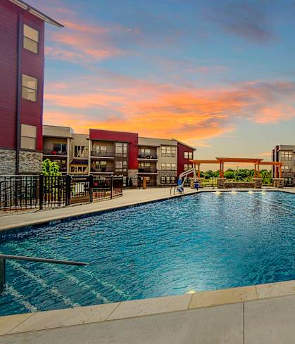 A swimming pool in front of apartment buildings.