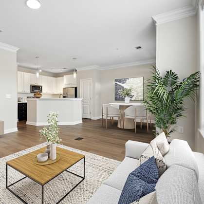 A living room with a white couch, a wooden coffee table, and a flat screen TV.