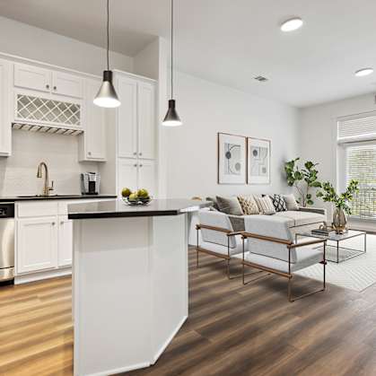 A modern kitchen with white cabinets and a wooden island.