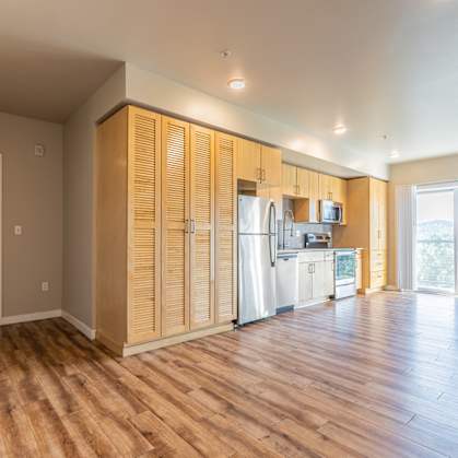 A kitchen with wooden cabinets and a white fridge.