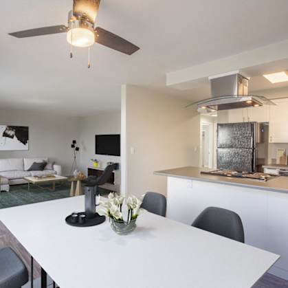 a living room with a white table and a kitchen