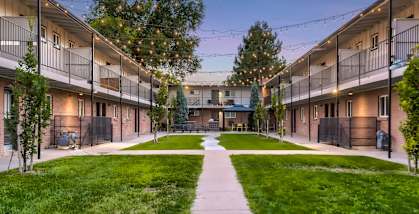 A courtyard surrounded by apartment buildings with a walkway in the middle.