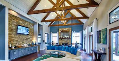 A large, open clubhouse with a stone wall and a wooden ceiling.