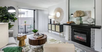 A modern living room with a fireplace and a large mirror on the wall.