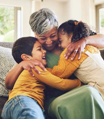 A woman and two children are sitting on a couch.