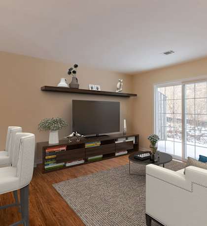 A living room with a white couch, a television, and a chair.