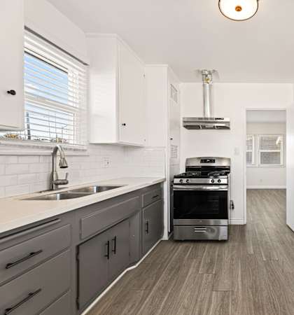 A kitchen with a stove and a sink.