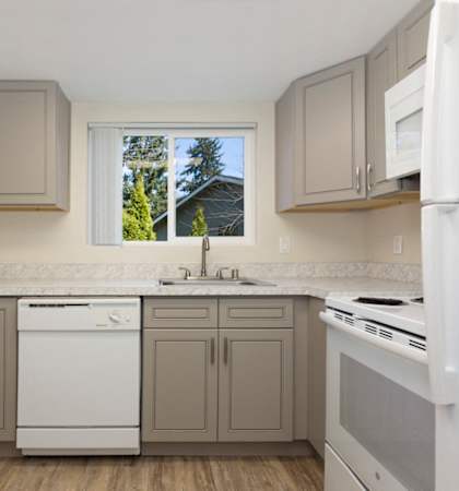 a kitchen with gray cabinets and white appliances