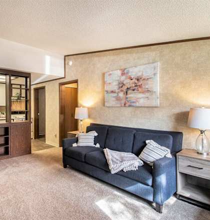 a living room with a blue couch and a mirror