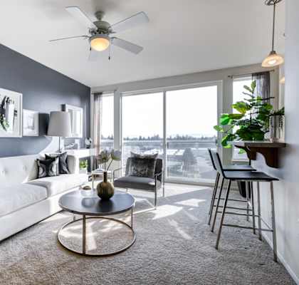 a living room with a large window and a ceiling fan