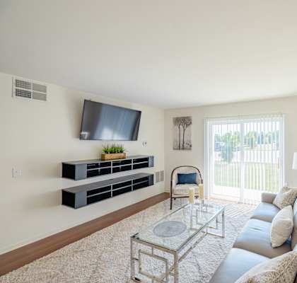 a living room with a couch and a glass coffee table and a television