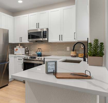a kitchen with stainless steel appliances and white cabinets