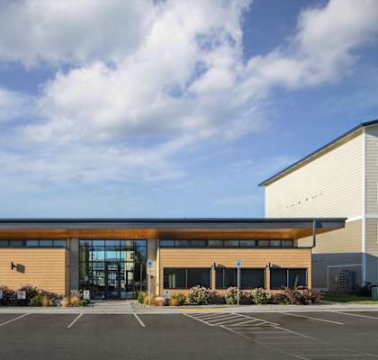 the front of a building with a parking lot