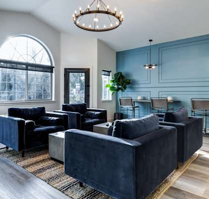a living room with blue walls and a chandelier