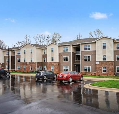 Apartment complex with cars parked in front.