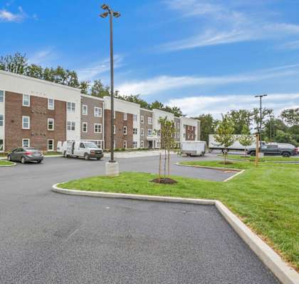 A parking lot in front of a multi-story apartment building.