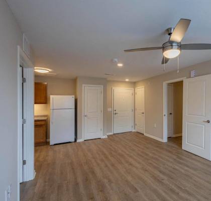A room with a ceiling fan and wooden floors.