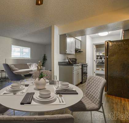 A dining room with a round table set for four.
