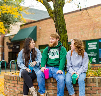a group of people standing in front of a tree