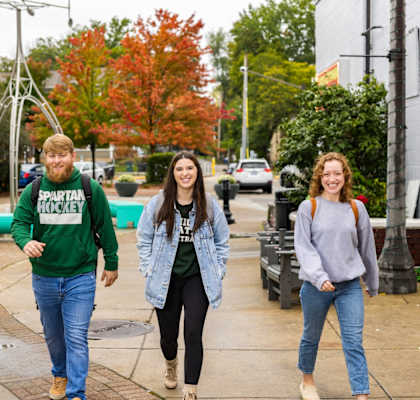 three young women playing hopscotch on a sidewalk