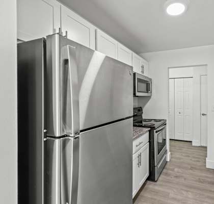 A modern kitchen with a stainless steel refrigerator and granite countertops.