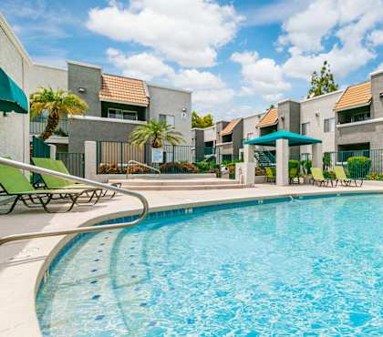 A swimming pool in front of apartment buildings.