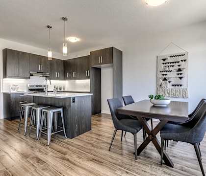 A modern kitchen with a dining table and chairs.