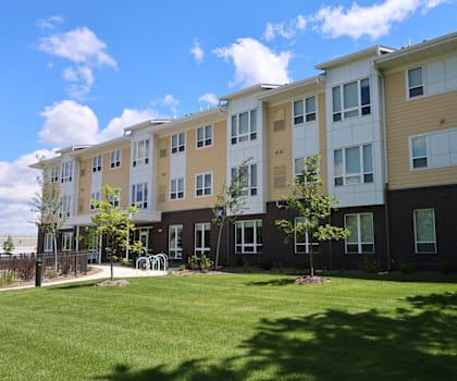 Apartment building with a grassy area in front.