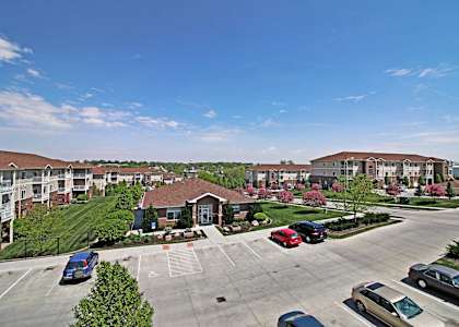 an aerial view of an apartment complex with cars in a parking lot