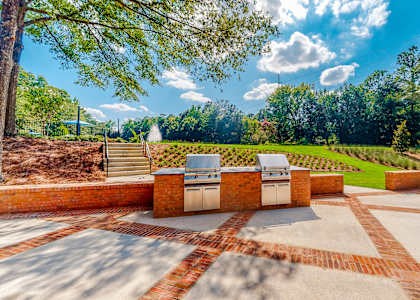 A backyard with a brick patio and a grill. at Inverness Cliffs, Birmingham, 35242