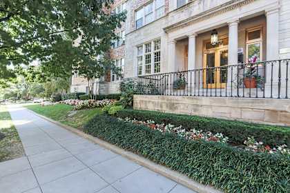 the front of a house with a sidewalk and a garden