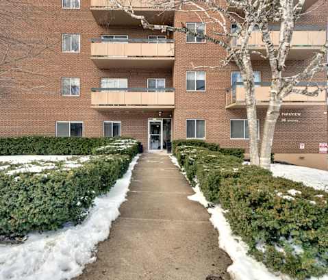 a brick apartment building with balconies and snow on the ground