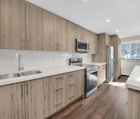 a kitchen with white countertops and wooden cabinets