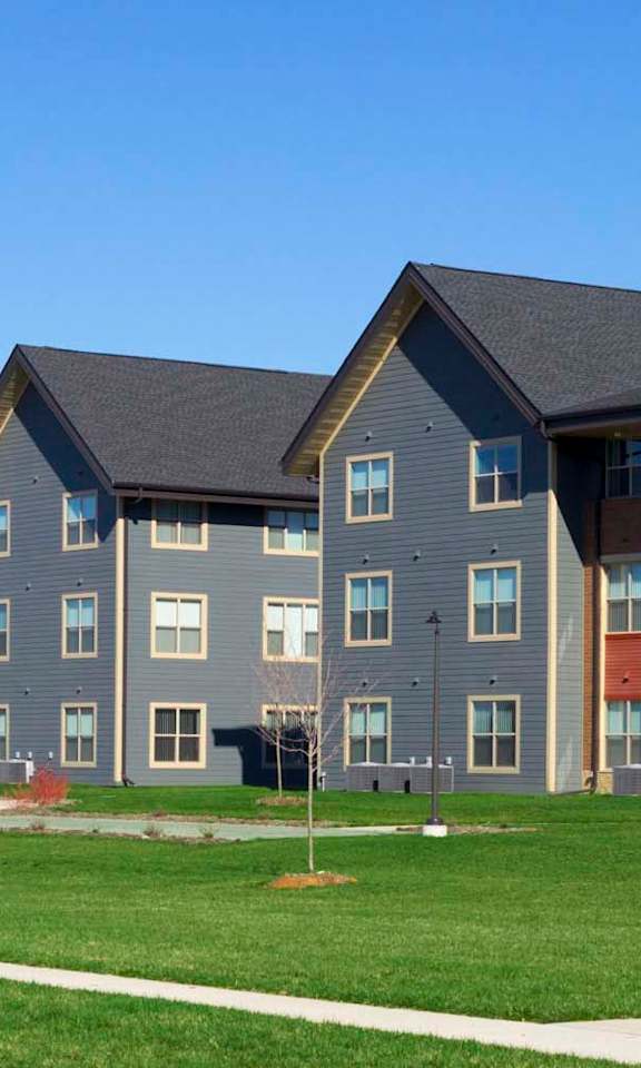 A large building with a grey and red facade.