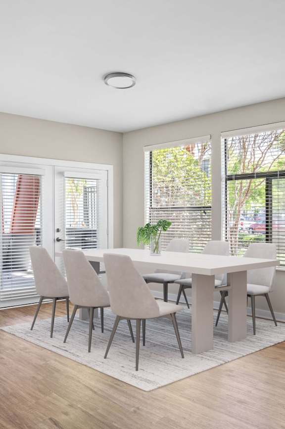 A dining room with a table and chairs.