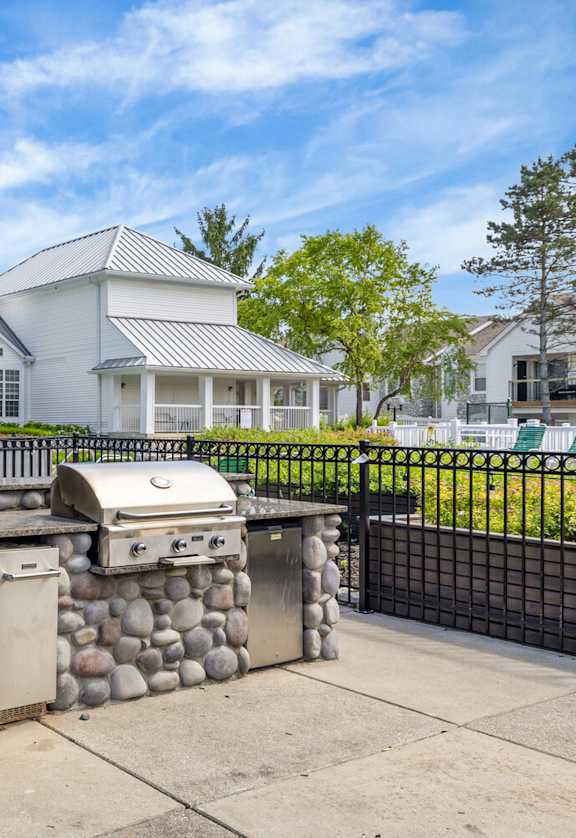 A backyard with a stone BBQ and a pool table.