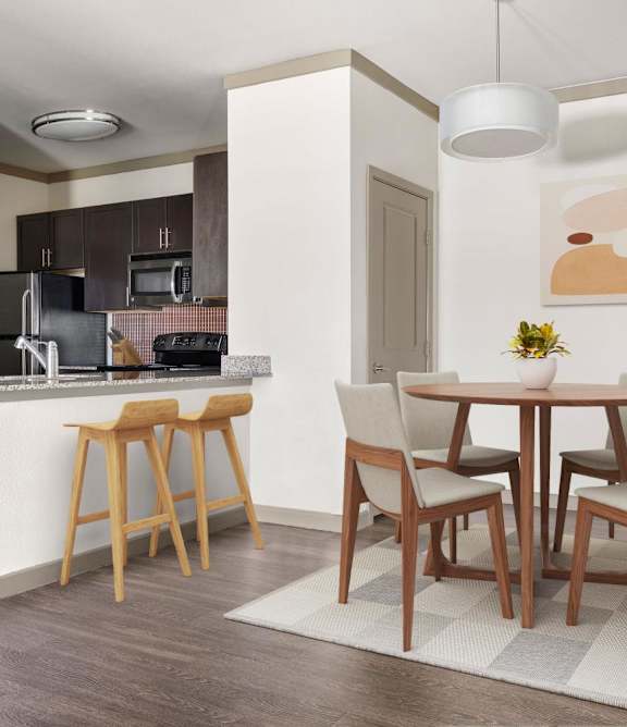 A kitchen with a dining table and chairs.