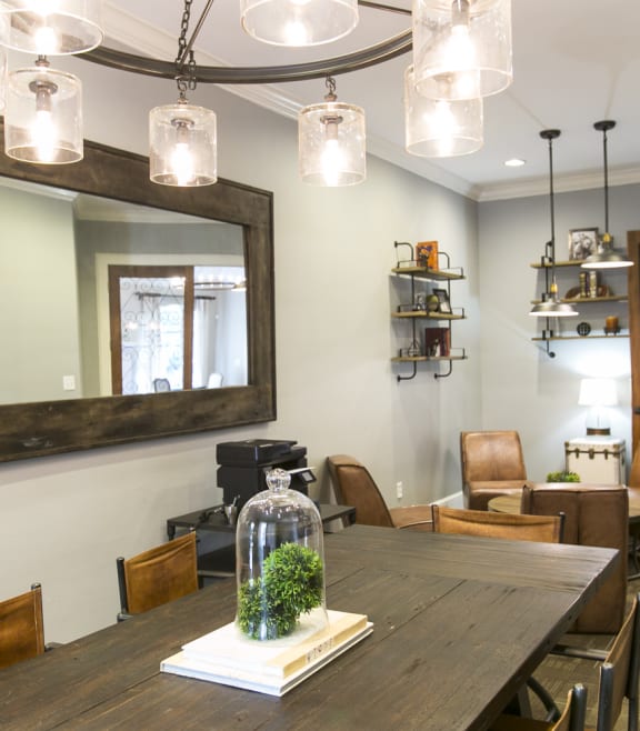 a dining room with a table and chairs and a mirror at The Park at Monterey Oaks, Austin