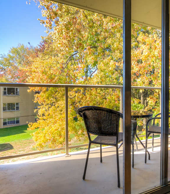 a balcony with a table and two chairs and a large window