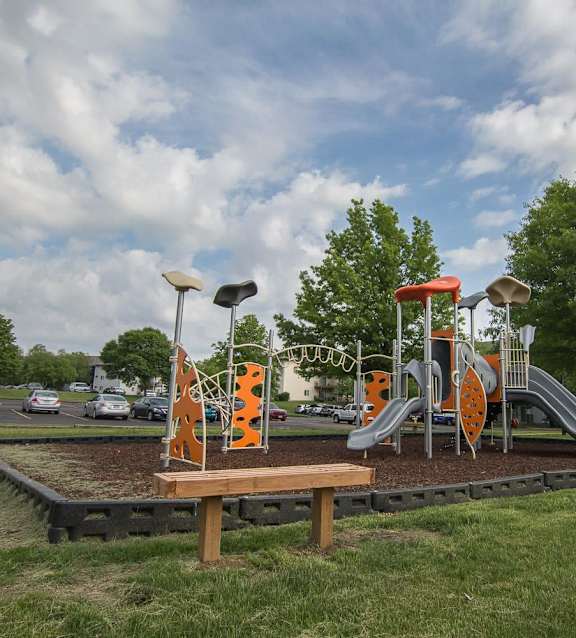 A playground with a slide, swings, and a climbing structure. at Somerset Apartments, Des Moines, IA, 50315